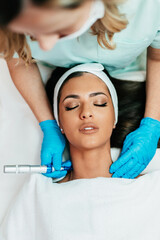 Professional cosmetologist making mesotherapy injection with dermapen on face for effective skin rejuvenation. Modern cosmetology spa treatment.