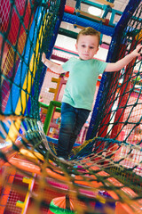little boy playing inside a tunnel in the playground voting balls