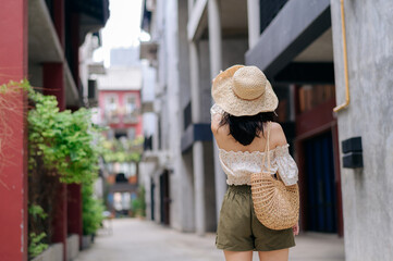 Fototapeta premium Happy youth asian woman with camera travels street city trip on leisure weekend. Young hipster female tourist sightseeing summer urban Bangkok destination. Asia summer tourism concept.