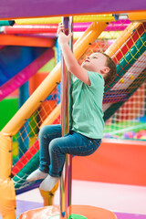 Fototapeta na wymiar boy on the playground with colored plastic balls