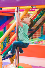 Fototapeta premium boy on the playground with colored plastic balls