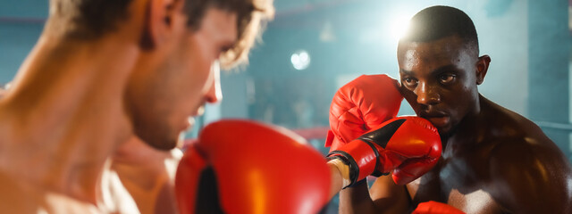 Two professional boxer man exercising in Thai boxing match or MMA in red gloves at the moment of impact on punching, background of ring during boxing fight, sport training for strength power body hit