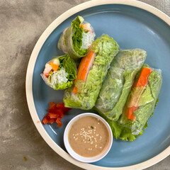 a plate of vegetable Spring roll based with peanut sauce served on blue plate in the cafe table