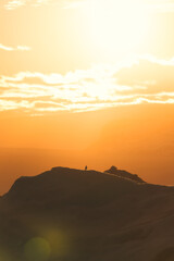 Bird perched on iceberg with orange sunset sky