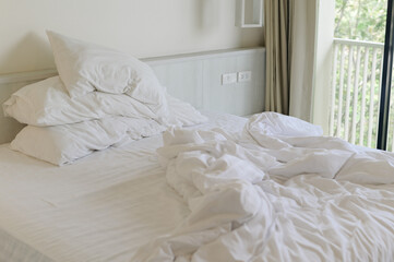 Fototapeta na wymiar an unmade white bed in bedroom