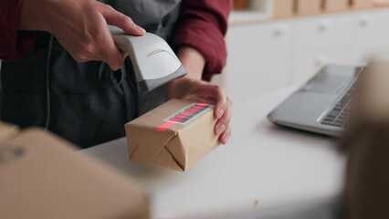 Business cooperation, Woman worker Responsibly scans a barcode with an electronic scanner at the workplace of a packer, Business owners works in a warehouse of an actual business, a box for parcels
