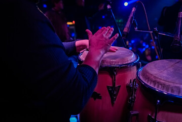 unrecognizable person playing congas, percussion musical instrument. concept band of cumbia, salsa, latin music.