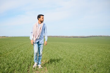 Naklejka na ściany i meble Portrait of young Indian Farmer wearing formal dress in green paddy field.