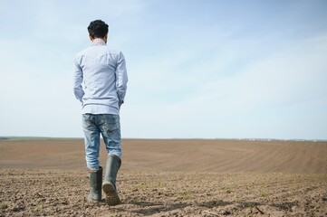 Young indian farmer at agriculture field.