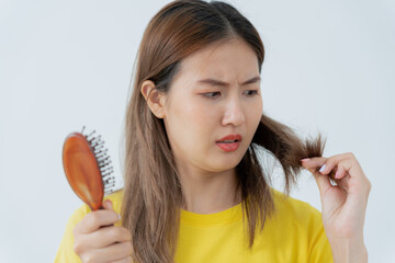 Asian woman very sad and upset looking at damaged hair, hair loss, hair thinning problem, vitamin...