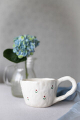 A cup of coffee and hydrangea flowers on a white  background