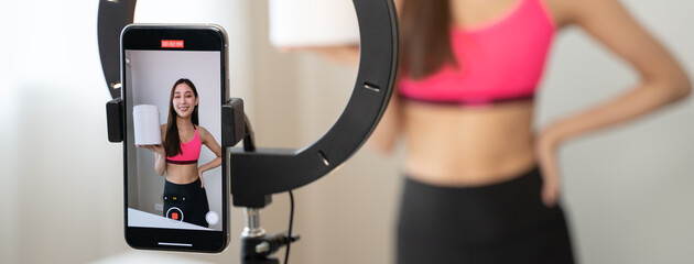 Asia healthy beautiful blogger influencer showing plant-based protein whey product on her live streaming channel to viral marketing brand online in wellness group follower.