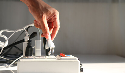 Man's hand is plugging the electrical plug into the socket. carefully