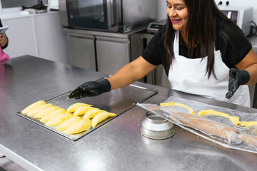 Authentic Colombian Delights: Middle-aged Woman Crafting Traditional Empanadas in Bakery