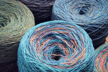 Round skeins of organic multi-coloured lambswool yarn.