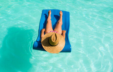 Middle-aged woman lounging lying on a mattress in the water