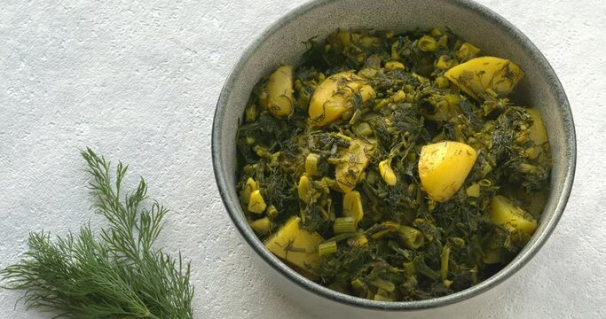 Homemade Aloo Suva. Potatoes and dill Indian style. Potato, garlic and a lot of fresh dill leaves cooked together. Table spin.
