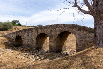 Old roman bridge in Almodovar, Portugal, over small dry river

