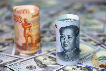 Chinese yuan and  Russian rubles rolled up on background of US dollars. Concept of exchange rate,...