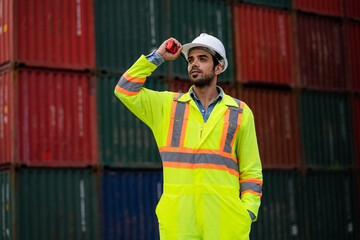 Male engineer worker uses walkie talkies and works in the shipping container industry, importing and exporting goods to the shipping business. concept of import-export of goods.