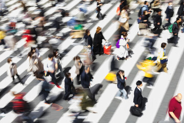 picture with intentional motion blur of crowds of people crossing a city street in Tokyo, Japan