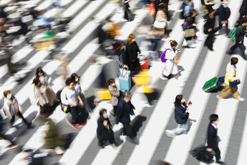 picture with intentional motion blur of crowds of people crossing a city street in Tokyo, Japan