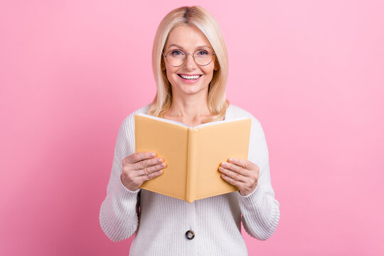 Photo of funny pleasant nice positive woman with bob hairdo knit cardigan read book excited story isolated on pink color background