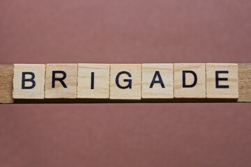 gray word brigade made of wooden square letters on brown background