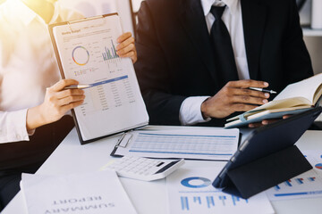 businessman working on desk office with using a calculator to calculate the numbers, finance accounting concept