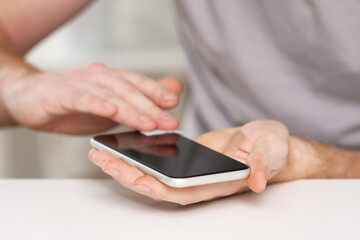A man cleans the phone screen to stick a protective tempered glass. Broken protective glass