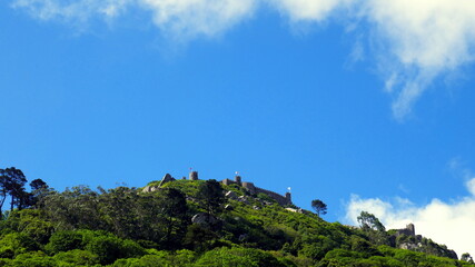 herrlicher Blick auf Berg von Sintra bei Lissabon mit weißen Wolken über grünem Wald
