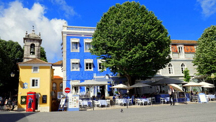 Straße mit schönen Häusern und grünen Bäumen in Sintra bei Lissabon unter blauem Himmel