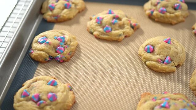 Time lapse. Freshly baked unicorn chocolate chip cookies on a baking sheet lined with a silicone mat.