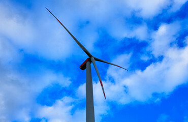 Wind Turbine Rotor Blades against Blue Sky and Clouds in Germany