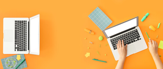 Banner with female hands, modern laptops and office stationery on orange background, top view