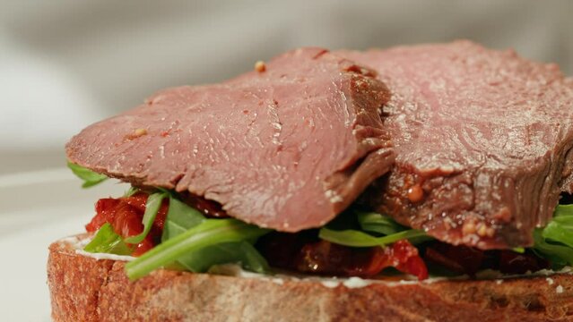American pastrami sandwich in New York ham meet cuts. chef cooking Famous thick cut sous vide beef sandwich on restaurant cafe kitchen.