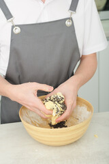 male chef hands making cookie dough with chokolate crumbs. close up view. vertical