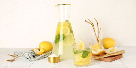 Glassware of fresh lemonade on light background
