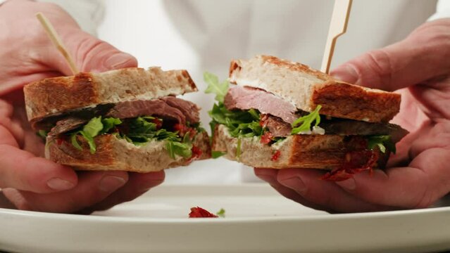 American pastrami sandwich in New York ham meet cuts. chef cooking Famous thick cut sous vide beef sandwich on restaurant cafe kitchen.