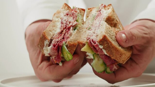 American pastrami sandwich in New York ham meet cuts. chef cooking Famous thick cut sous vide beef sandwich on restaurant cafe kitchen.