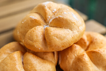 Kaiser rolls on wooden table, closeup