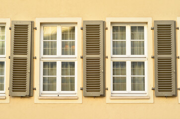 Fototapeta na wymiar View of residential building with white windows and shutters
