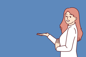 Woman promoter stretches out hand with raised palm to present new product or discount card for regular customers. Promoter girl with long hair stands near copy space and looks at screen smiling