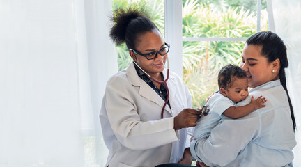 African doctor woman using a stethoscope, checking the respiratory system and heartbeat of a...