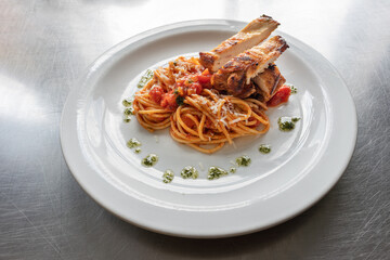 Elevated Elegance: Spaghetti with Tomato Sauce and Sliced Roast Chicken Breast on a White Plate