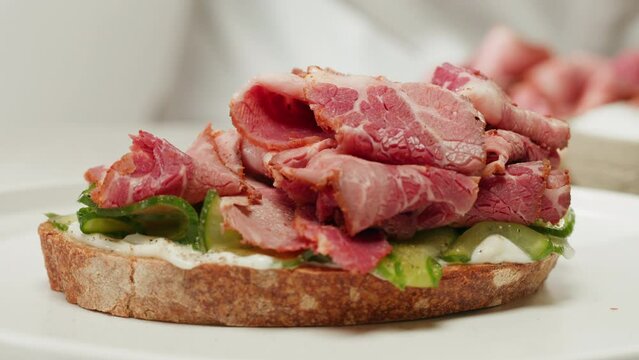 American pastrami sandwich in New York ham meet cuts. chef cooking Famous thick cut sous vide beef sandwich on restaurant cafe kitchen.