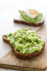 Board of tasty avocado toast on table