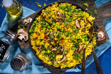 Homemade vegetarian pilaf with vegetables, green pea and champignon mushrooms 