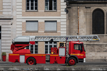 Paris, France - 05 19 2023: View of a red fire truck with foldable ladder at the Canal Saint-Martin.
