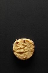 One whole wheat chip cookie on a black background. Top-down view. Food Flat lay.